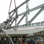 Jeder der neun fast 50 Tonnen schweren Dachträger für die Eingangshalle wird punktgenau aufgesetzt.